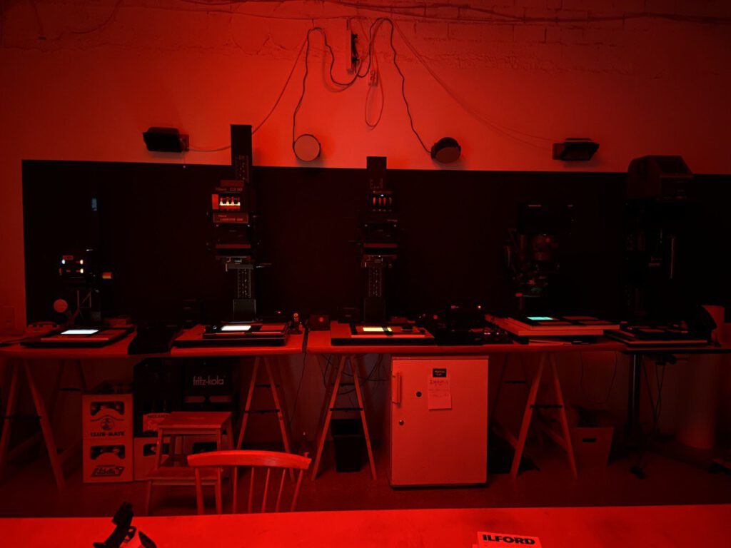 enlargers in a photographic dark room, all in red light